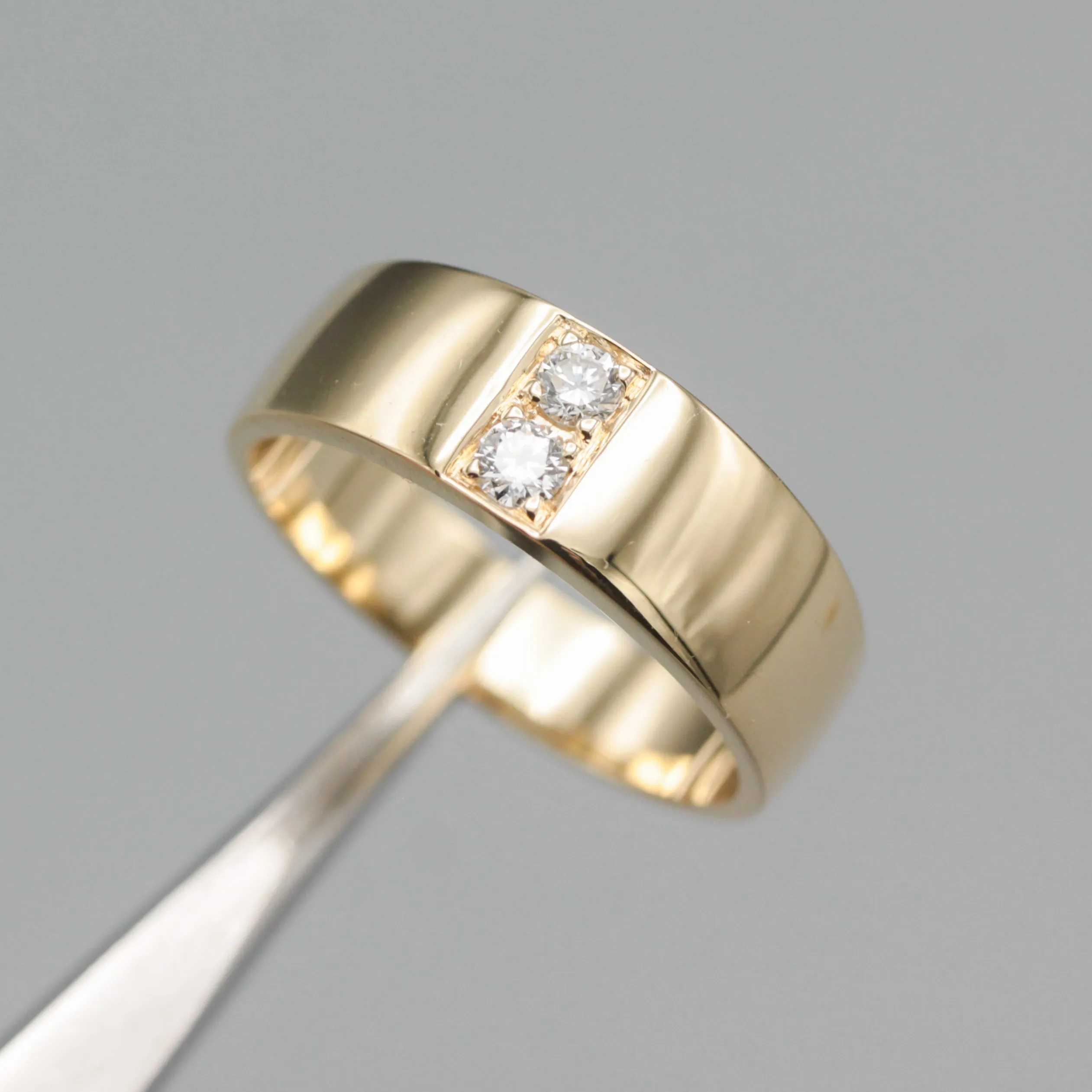 Men's ring in 18k gold featuring a high-polished band with 2 round faceted diamonds